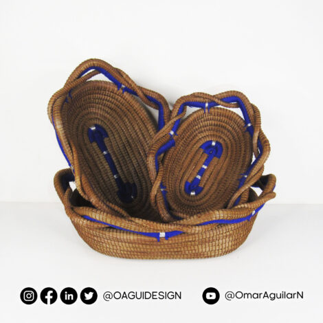Set de 3 canastas ovaladas tejidas en acícula de pino, borde entrenzado, color azul y detalles plateados.